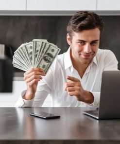 Fistful of money - sitting at laptop